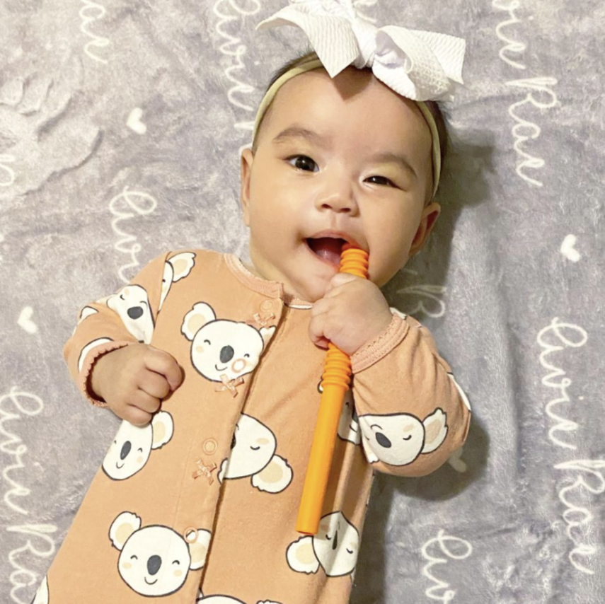 Happy baby using a teething tube