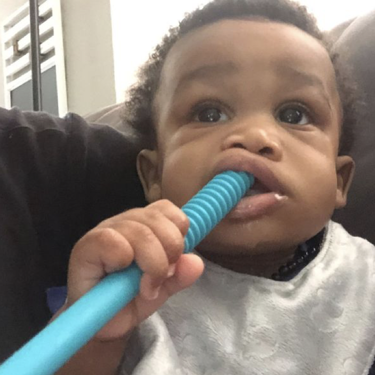 Happy baby using a teething tube